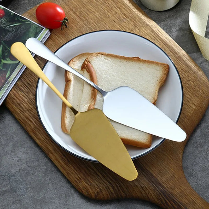 Cake server and gold cake spatula on a plate with bread