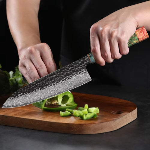 Chef using 8-inch Damascus Steel Chef Knife to slice vegetables on wooden cutting board.
